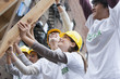Volunteers lifting construction frame together