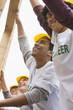 Volunteers lifting construction frame together