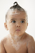 Mixed race baby girl taking a bath