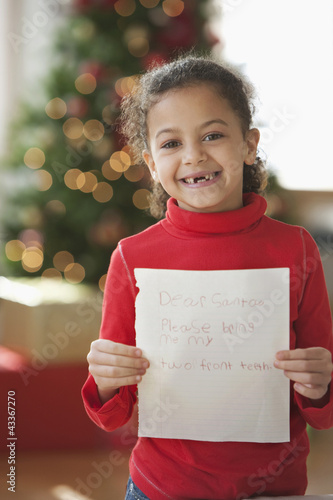 Photo: Hispanic girl writing Christmas letter to Santa Hispanic girl writing Christmas letter to Santa
