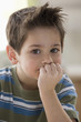 Caucasian boy with hand on chin