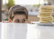 Caucasian boy looking at stack of pancakes
