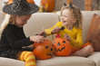 Caucasian girls in Halloween costumes eating candy