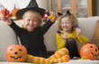 Caucasian girls in Halloween costumes eating candy