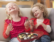 Caucasian girls eating Valentine's candy