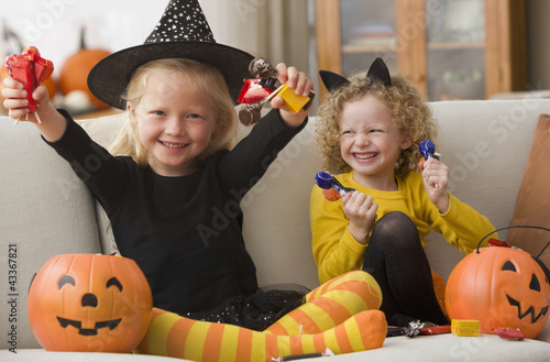 Photo: Caucasian girls in Halloween costumes eating candy Caucasian girls in Halloween costumes eating candy