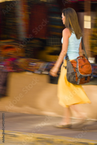 Photo: Hispanic woman walking on sidewalk Hispanic woman walking on sidewalk