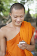 Cambodian monk text messaging on cell phone