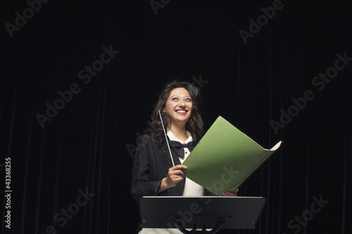 Photo: Smiling mixed race conductor holding folder Smiling mixed race conductor holding folder