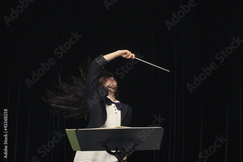 Photo: Mixed race conductor pointing baton Mixed race conductor pointing baton