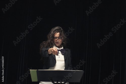 Photo: Mixed race conductor pointing baton Mixed race conductor pointing baton