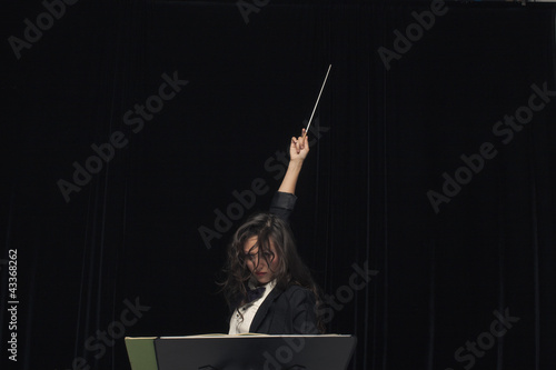Photo: Mixed race conductor pointing baton Mixed race conductor pointing baton