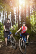 Couple riding mountain bike in forest
