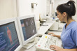 Hispanic nurse working on computer in hospital