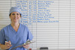 Doctor standing next to schedule whiteboard in hospital
