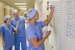 Doctor writing on schedule whiteboard in hospital