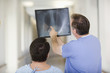 Doctor with x-ray talking to patient in hospital corridor