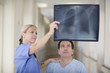 Doctor with x-ray talking to patient in hospital corridor
