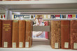 Caucasian woman taking book from shelf in library