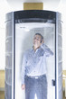 Indian man using cell phone in isolation booth