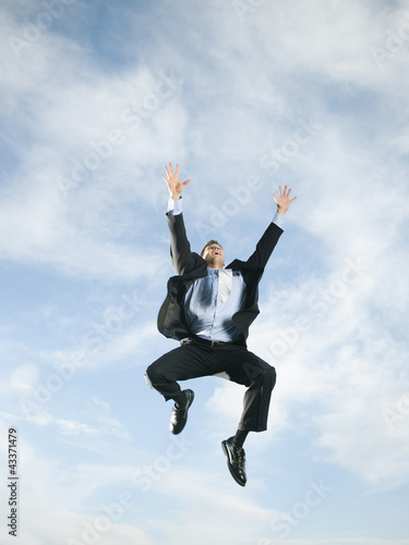 Photo: Caucasian businessman jumping in air Caucasian businessman jumping in air
