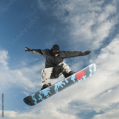 Photo: Caucasian man on snowboard in mid-air Caucasian man on snowboard in mid-air