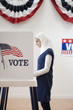 Middle Eastern voter voting in polling place
