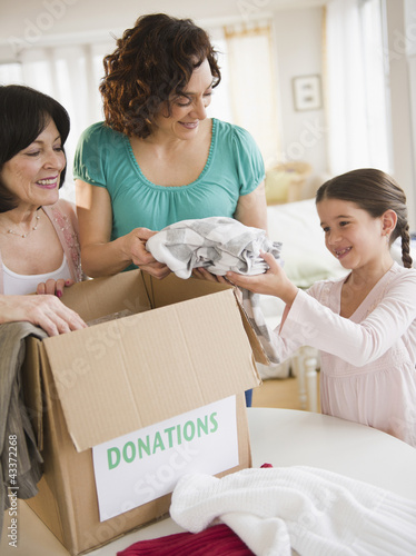Photo: Family packing box of clothing donations Family packing box of clothing donations