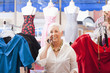 Caucasian woman using phone in dress shop
