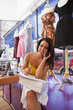 Hispanic woman working in dress shop and talking on phone