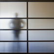 Businessman standing behind glass wall