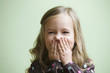 Caucasian girl covering her mouth