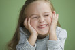 Grinning Caucasian girl with head in hands