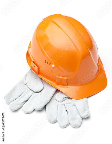Photo: Orange hard hat on white gloves, isolated on white Orange hard hat on white gloves, isolated on white