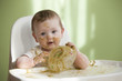 Caucasian baby girl feeding herself