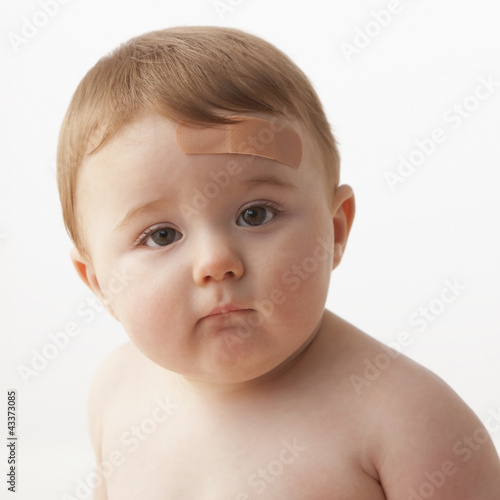 Photo: Caucasian baby boy with bandage on forehead Caucasian baby boy with bandage on forehead