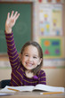 Caucasian girl raising hand in classroom