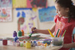 Hispanic girl painting in art class