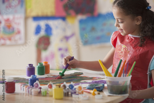 Photo: Hispanic girl painting in art class Hispanic girl painting in art class