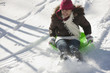 Hispanic girl sledding on snow covered hill