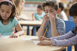 Caucasian boy blowing nose in classroom