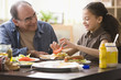 Hispanic girl and grandfather making sandwich