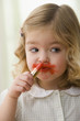 Caucasian girl putting on lipstick