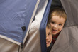 Caucasian brothers peering out of tent