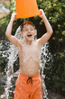 Caucasian boy pouring water over himself