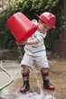 Caucasian boy playing with bucket wearing fireman's hat