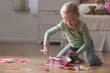 Caucasian girl cleaning up mess from floor