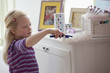 Caucasian girl dusting dresser