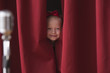 Caucasian girl peering from backstage