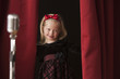 Caucasian girl peering from backstage
